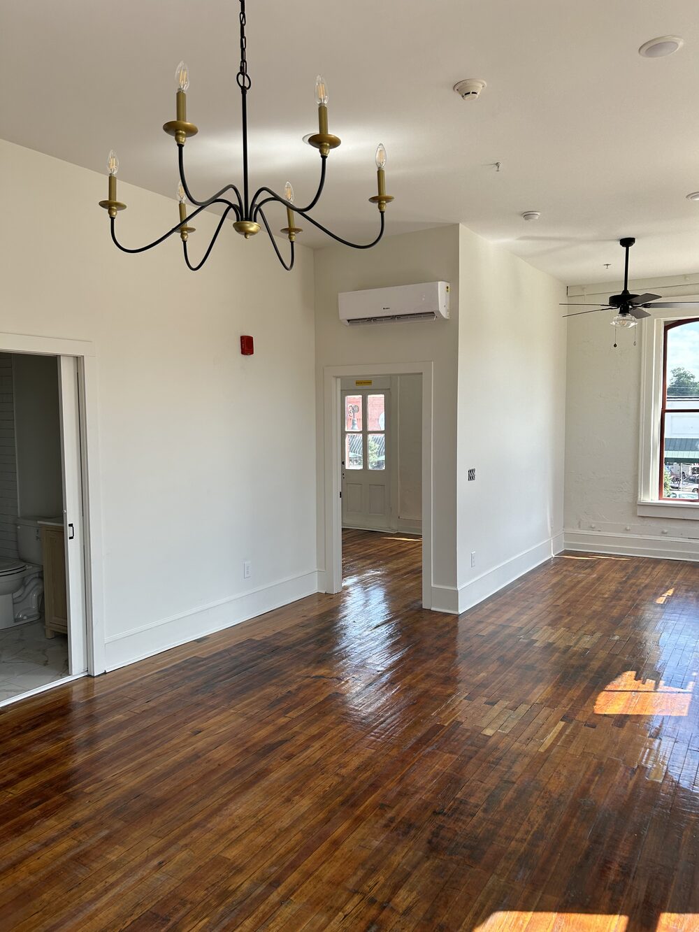 Open living area with hardwood floors and natural light